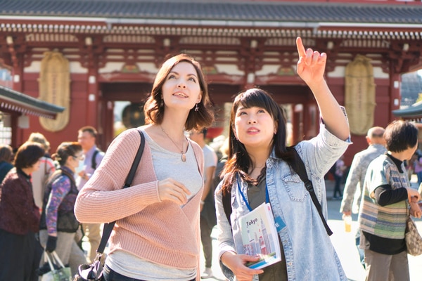 Local Japanese guide helping visitors explore a traditional temple in Japan